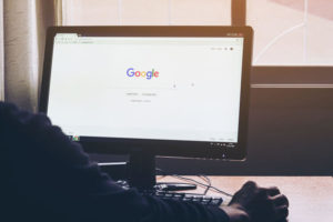 Man on a computer Browsing Google is the biggest Internet search engine in the world.