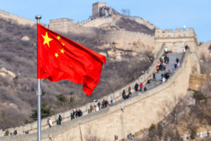 The Great Wall of China on the background and chinese red flag
