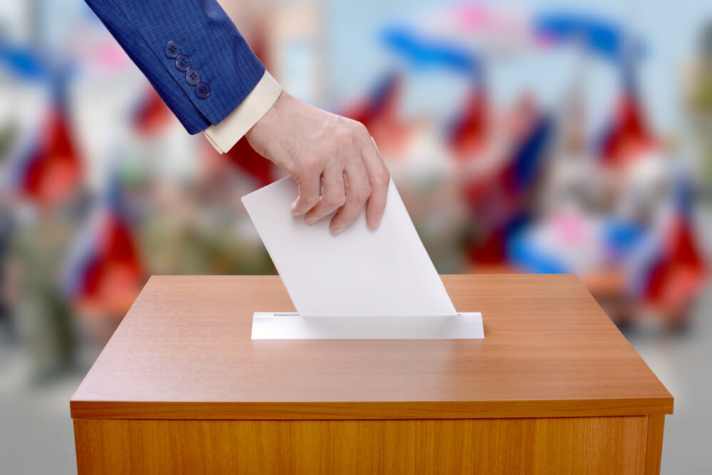 Man votes by throwing a ballot in the ballot box (1)